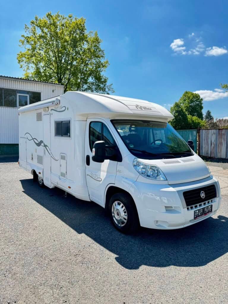Bílý obyný vůz Fiat Ducato Miller na parkovišti