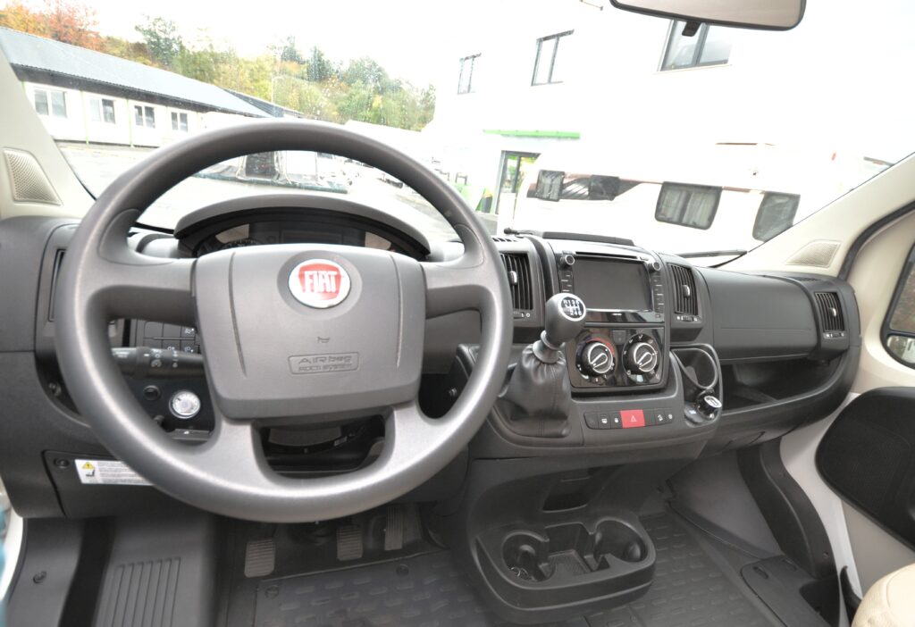 Interiér obytného auta Fiat s moderním designem a vybavením pro pohodlné cestování.