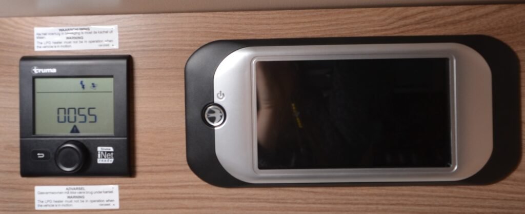 Obrázek ukazuje ovládací panel topení značky Truma pro obytné auto. Panel je moderní a přehledný.