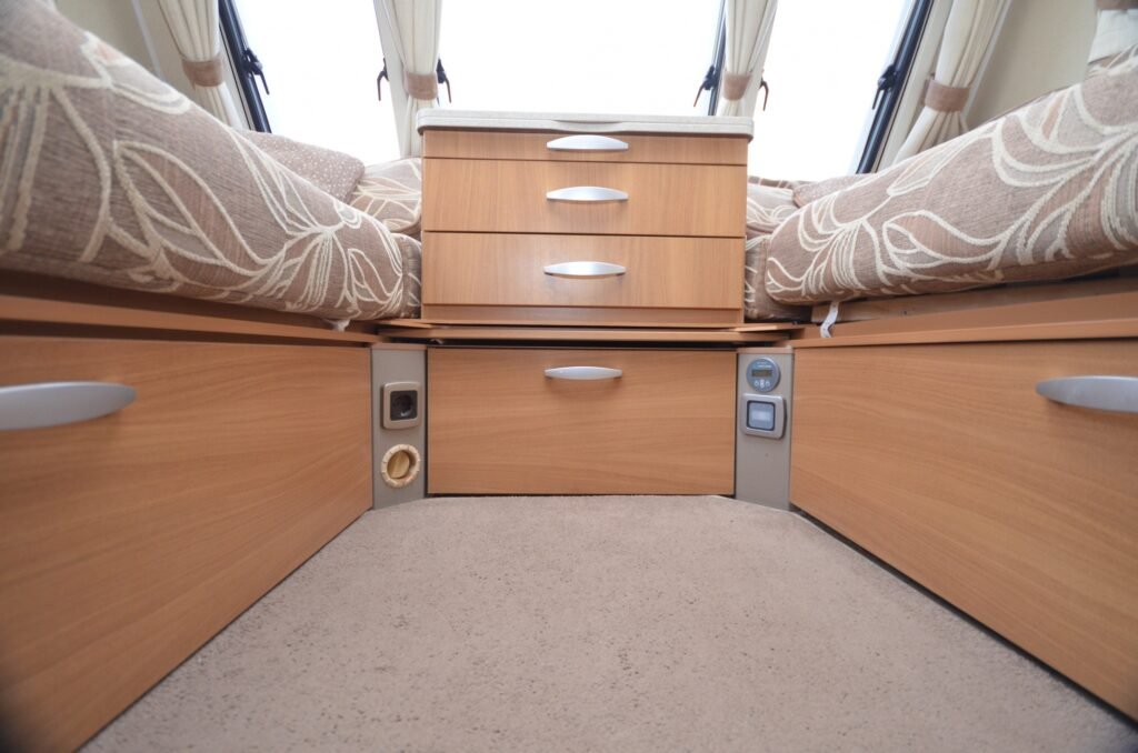 Obrázek interiéru karavanu s prostornými zásuvkami a pohodlnými sezeními. Ideální pro cestování a odpočinek.