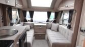 Luxusní interiér karavanu s prostornými sedacími částmi a moderní kuchyňkou. Ideální pro dobrodružství.