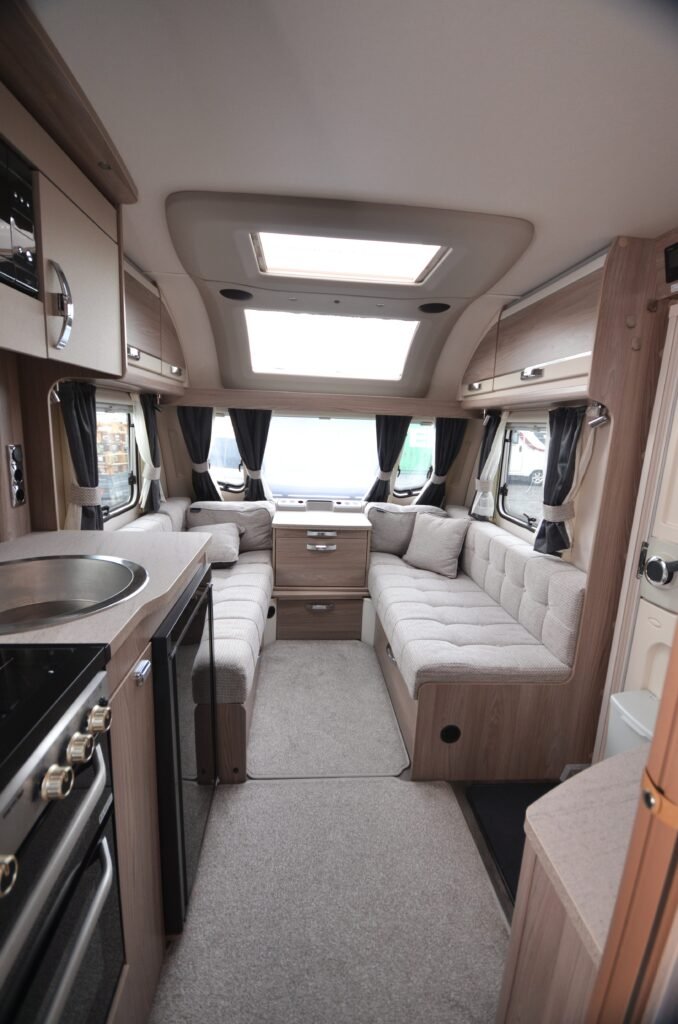 Luxusní interiér karavanu s prostornými sedacími částmi a moderní kuchyňkou. Ideální pro dobrodružství.