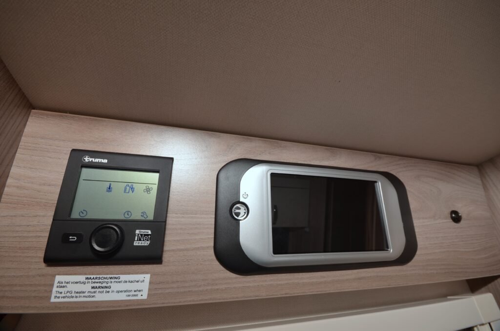 Obrázek zobrazuje ovládací panel pro topení v obytném autě. Model a značka nejsou uvedeny.