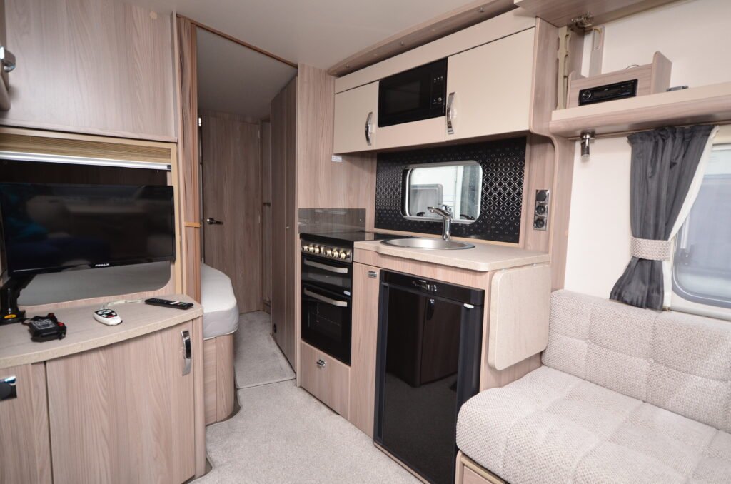 Stylový karavan s moderním interiérem, kuchyní a obývací částí. Ideální pro pohodlné cestování a kempování.