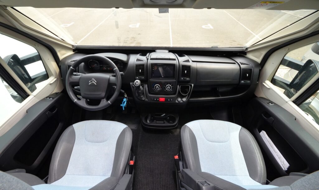 Interiér obytného auta Citroën s pohodlnými sedadly a moderními ovládacími prvky. Ideální pro cestování.