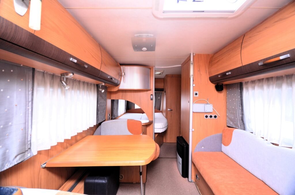 Krásný interiér karavanu, moderní design s dřevěnými prvky a pohodlným sezením. Ideální pro dobrodružství.
