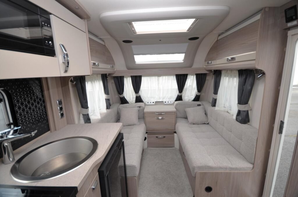 Interiér karavanu s moderním designem a pohodlným sezením. Ideální pro cestování a relaxaci.