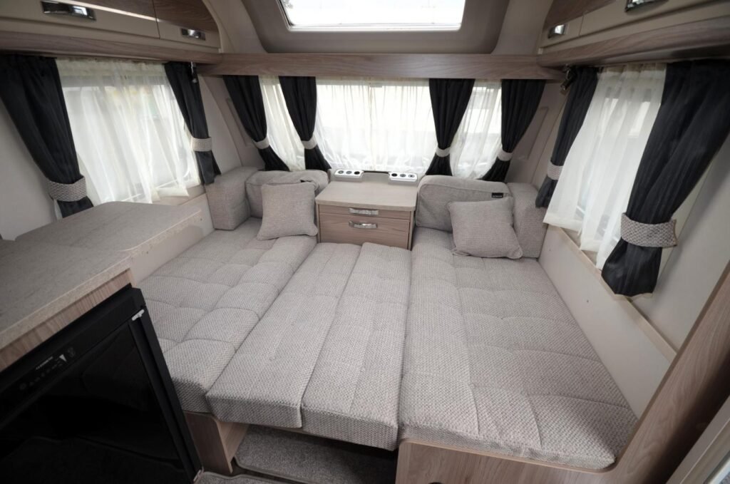 Interiér karavanu s pohodlnými sedacími prostorami a moderním designem. Ideální pro cestování a odpočinek.