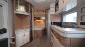 Interiér karavanu s moderní kuchyní a komfortním obývacím prostorem. Ideální pro dobrodružství na cestách.