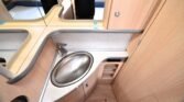 Obrázek interiéru obytného vozu s moderním umyvadlem a dřezem v příjemném designu.