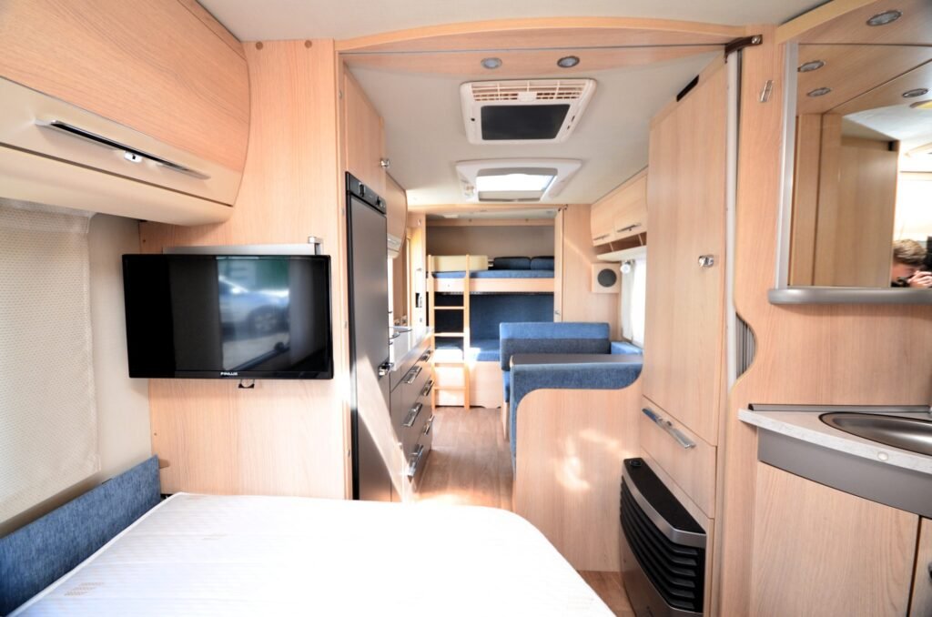 Interiér obytného auta s moderním designem a pohodlným uspořádáním, ideální pro cestování a odpočinek.