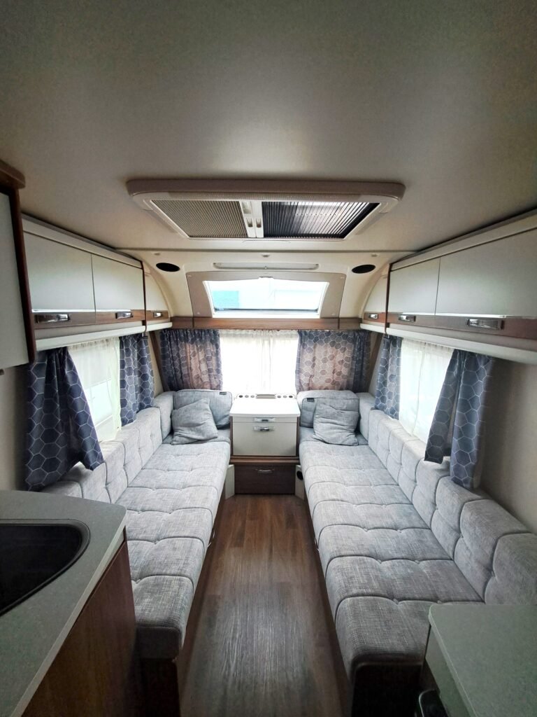 Interiér karavanu s pohodlnými sedacími prostory a moderním designem. Ideální pro vaši dobrodružnou cestu!