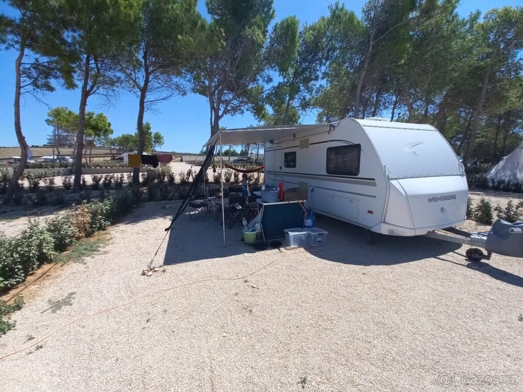 Karavan Weinsberg v přírodě, ideální pro dovolenou a relaxaci pod slunečníkem. Skvělé místo pro kempování!