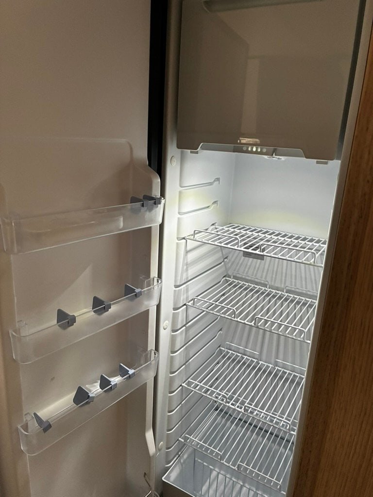 Obrázek ukazuje prostor chlazení v obytném autě, ideální pro skladování potravin během cestování.