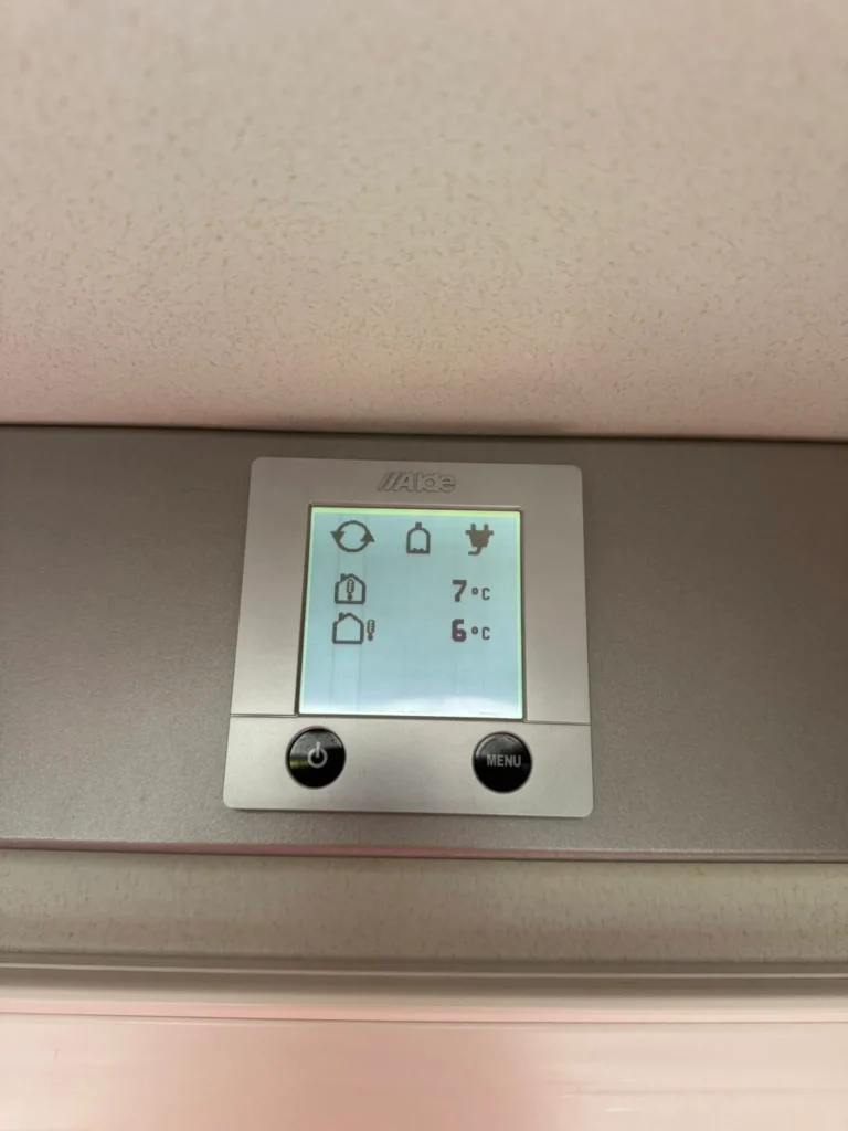 Obrázek ukazuje ovládací panel vytápění v obytném voze. Teploty jsou 7 °C a 6 °C.