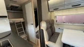 Moderní interiér karavanu se sedací soupravou a kuchyňským koutem. Všestranné využití pro cestování a odpočinek.