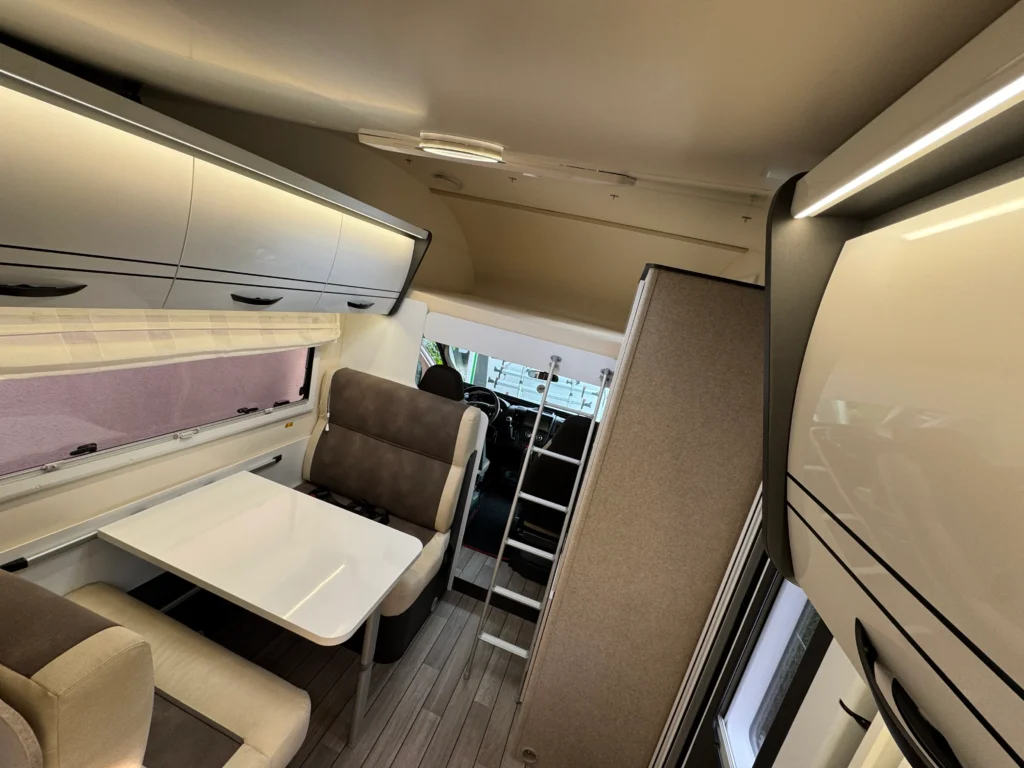 Interiér obytného auta s moderním designem a pohodlným posezením. Ideální pro cestování a odpočinek.