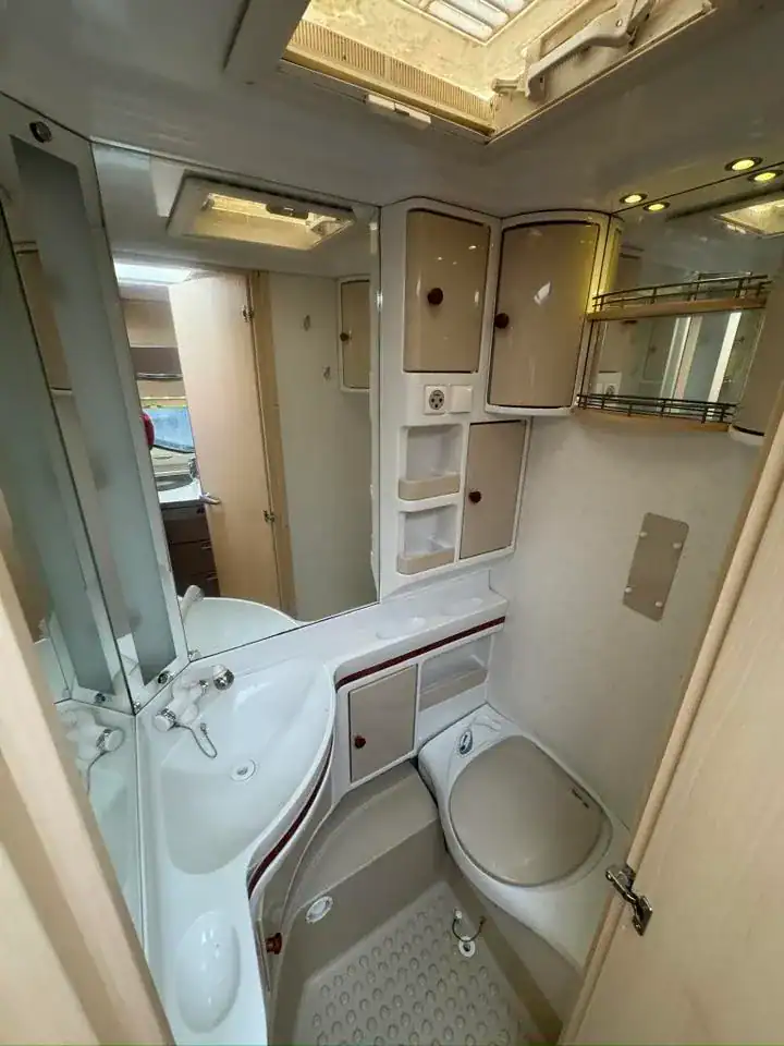 Interiér koupelny s umyvadlem a toaletou, moderní design a dostatek úložného prostoru.