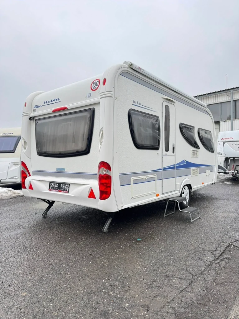 Na obrázku je obytný přívěs značky Hobby, model La Vita, viditelná zadní část.