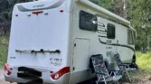 Obytné auto Hymer Exsis-I, ideální pro kempování v přírodě se dvěma židlemi vedle.