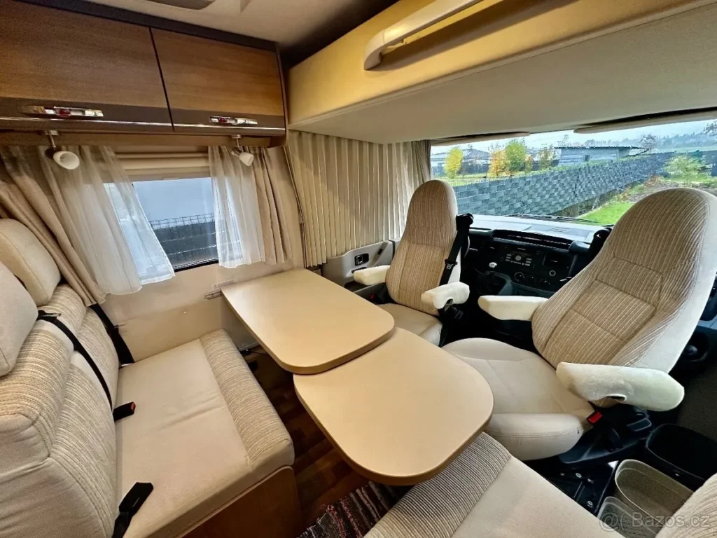 Obrázek interiéru obytného auta s pohodlnými sedadly a stolky pro relaxaci. Moderní design pro cestování.