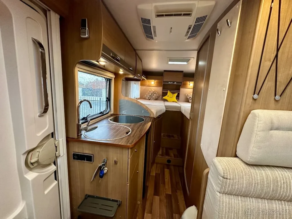 Interiér obytného auta s moderním designem a příjemným vybavením pro komfortní cestování.