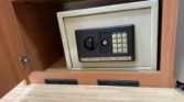 Obrázek ukazuje elektronický trezor v interiéru karavanu, ideální pro bezpečné uložení cenností.