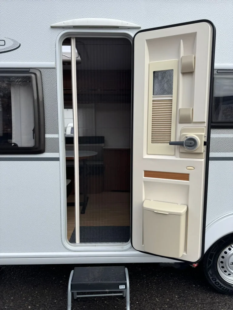 Obrázek zobrazuje karavan s otevřenými dveřmi, který nabízí pohodlný vstup do interiéru.