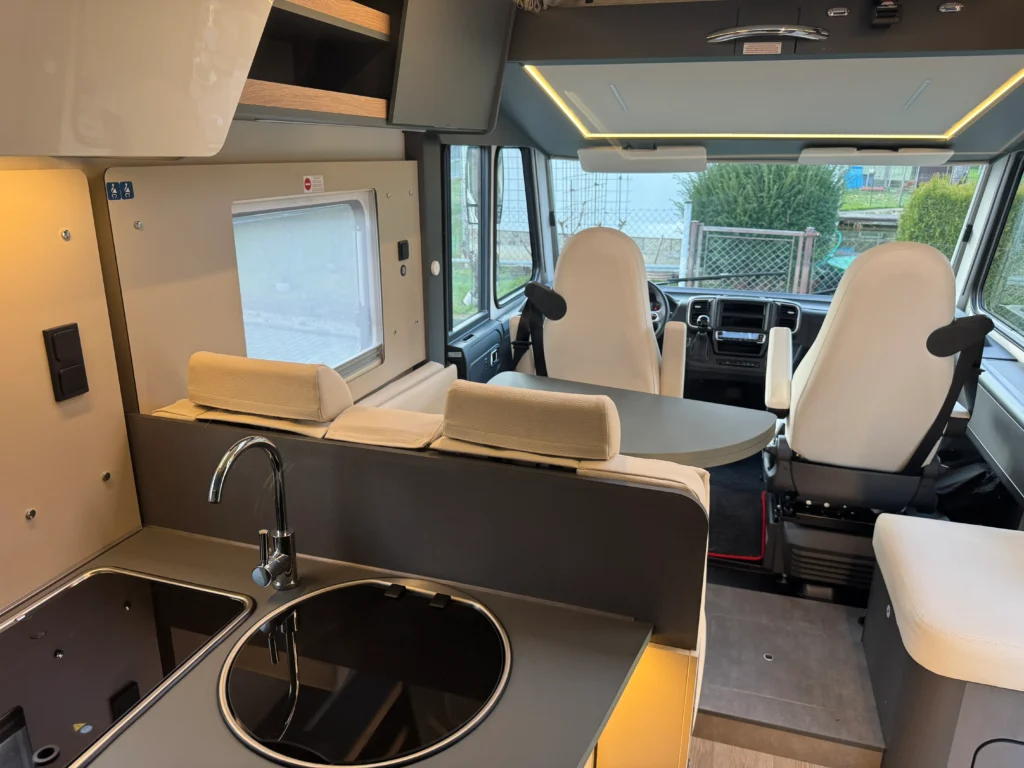 Obytné auto s moderním interiérem, kuchyňkou a pohodlnými sedadly. Ideální pro pohodlné cestování a kempování.