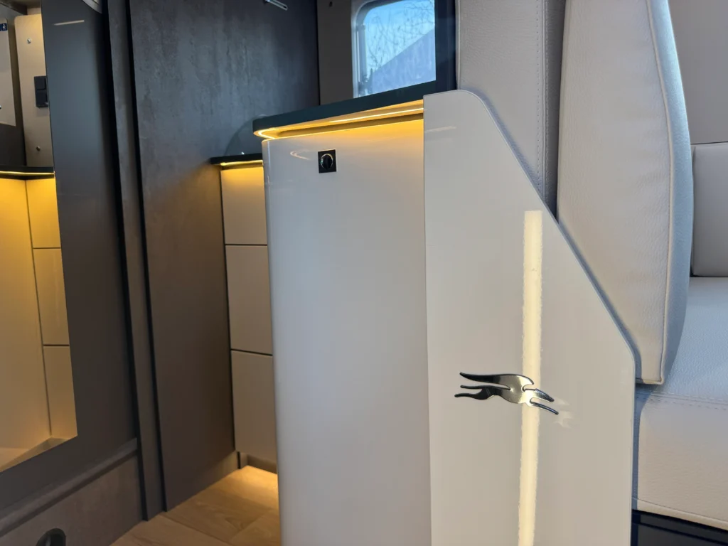 Na obrázku je interiér obytného auta s moderním designem a subtilním osvětlením.