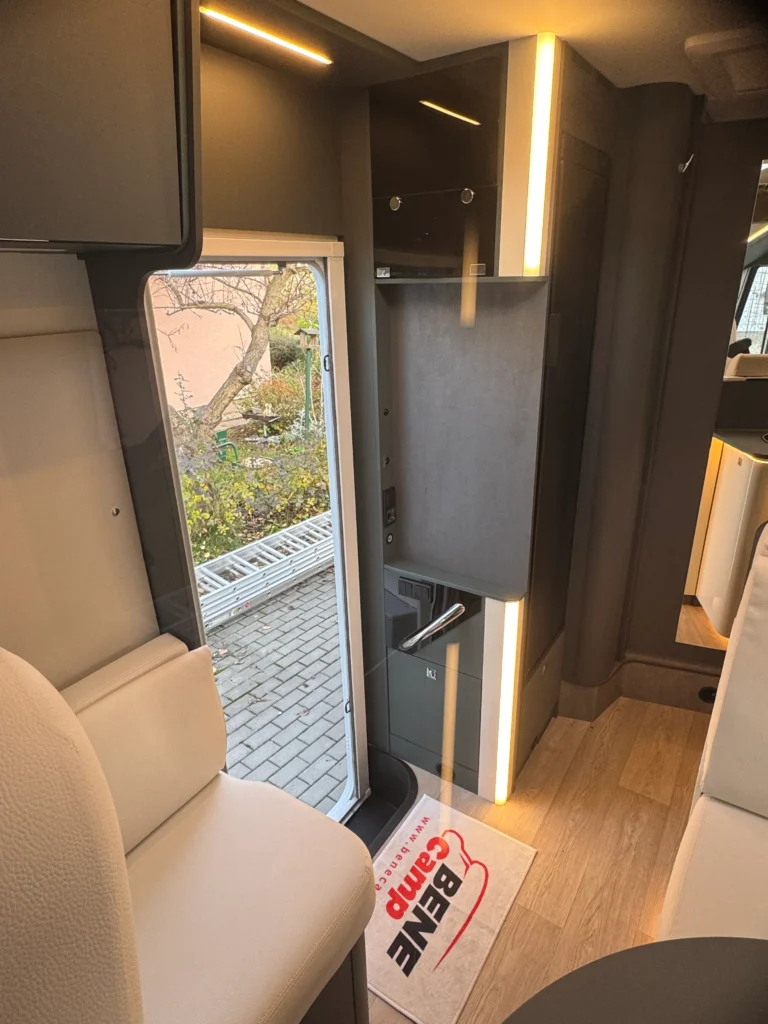 Interiér obytného auta, moderní design, pohodlné sezení, dostatek prostoru. Značka a model nejsou viditelné.