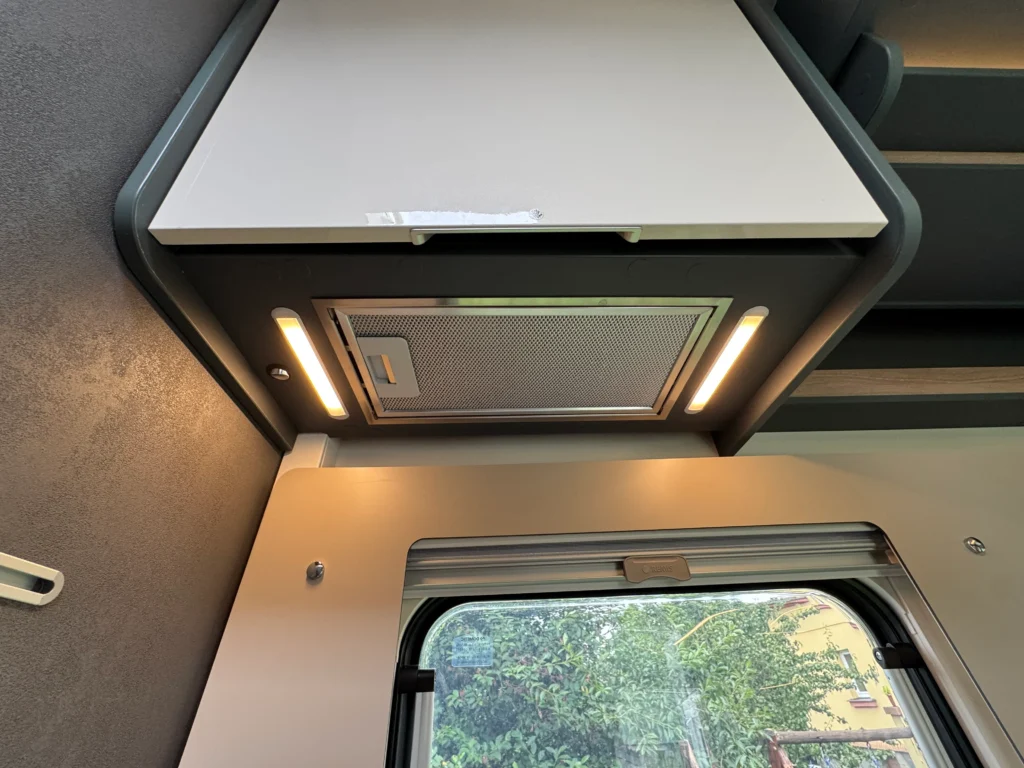 Obrázek interiéru obytného auta, moderní osvětlení a design. Ideální pro pohodlné cestování.