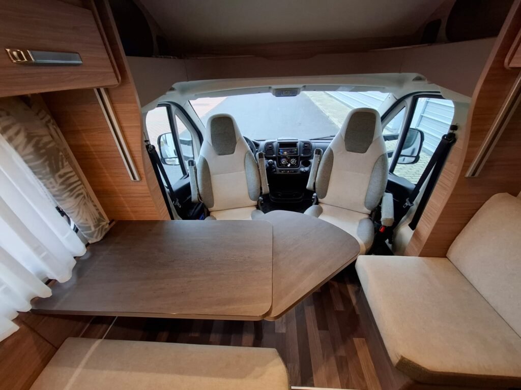 Obytné auto s prostorným interiérem a pohodlným sezením na stolku. Ideální pro cestování a relaxaci.