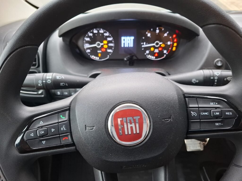 Obrázek ukazuje interiér obytného auta značky Fiat, zaměřený na volant a přístroje.