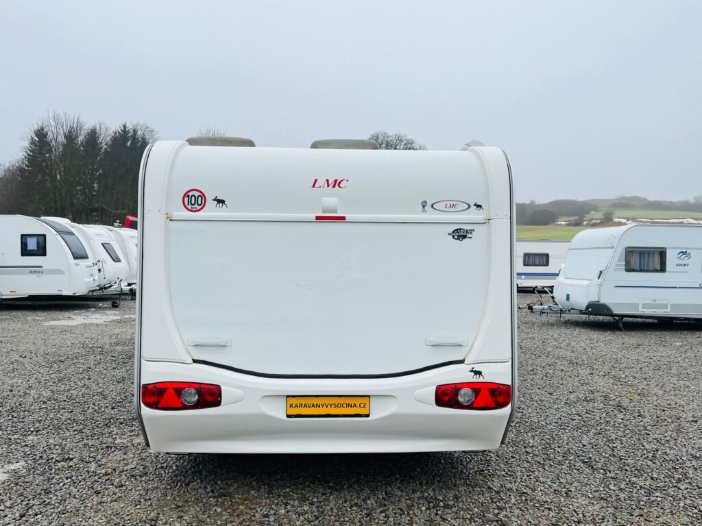 Karavan LMC s bílou karoserií, výborný pro rodinné dobrodružství v přírodě. Ideální volba pro fanoušky cestování!