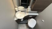 Obrázek interiéru koupelny obytného auta s moderním umyvadlem a toaletou. Elegantní design a funkčnost.