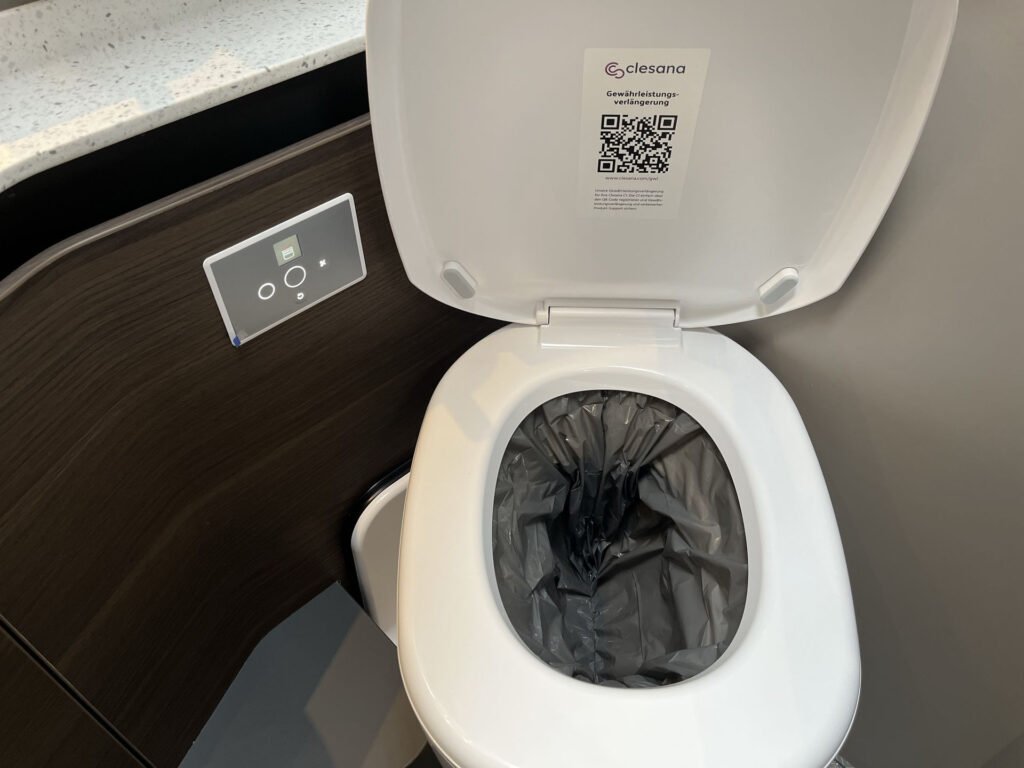 Obrázek ukazuje moderní toaletu v obytném voze, design s elektronickým ovládáním.