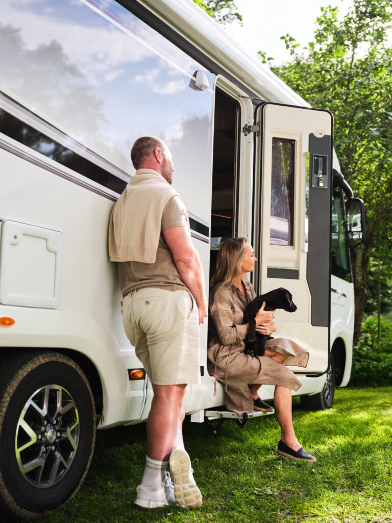 Obytné auto s moderním designem, ideální pro dovolenou v přírodě. Ve společnosti psa a pohodový pár užívají relaxaci.