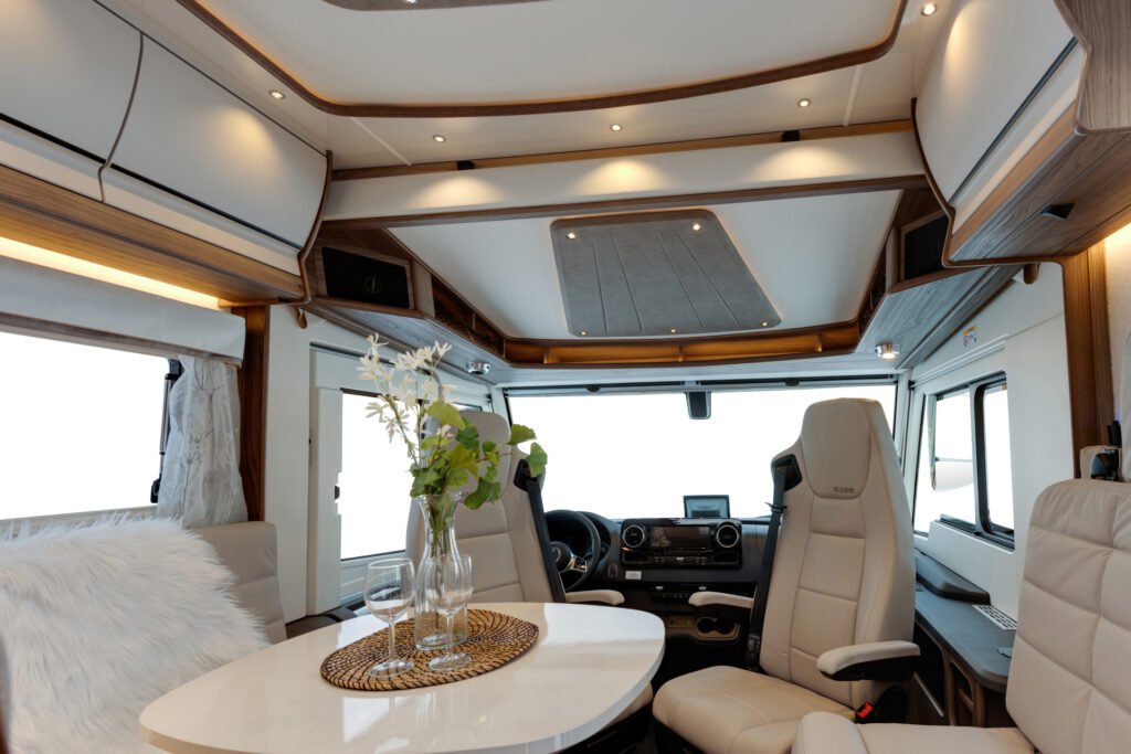 Moderní interiér obytného auta s elegantním designem a světlými barvami. Ideální pro pohodlné cestování.