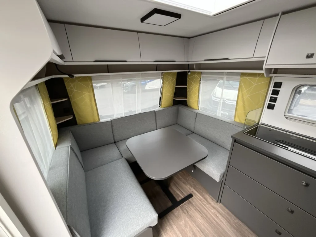 Interiér karavanu s moderním uspořádáním a pohodlným sezením. Ideální pro rodinné výlety a relaxaci.
