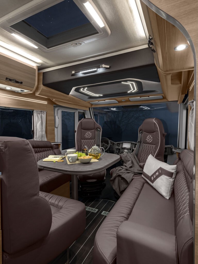 Interiér obytňáku s moderním designem a pohodlným sezením, ideální pro cestování a odpočinek.