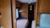 Interiér karavanu s pohodlnými lůžky a kuchyňským koutem. Ideální pro pohodlné cestování a rekreaci.
