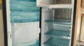 Obrázek ukazuje lednici v obytném voze Dometic, ideální pro uchování potravin na cestách.