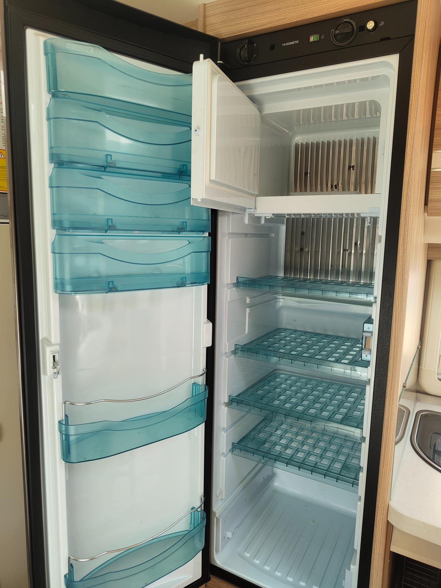 Obrázek ukazuje lednici v obytném voze Dometic, ideální pro uchování potravin na cestách.