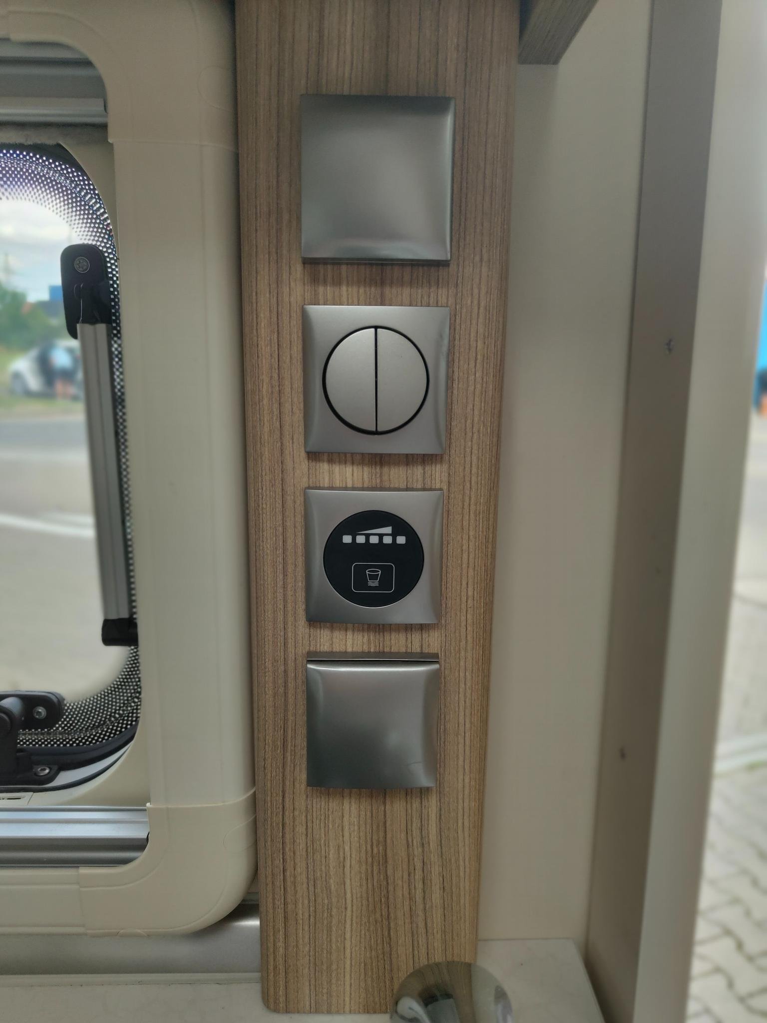 Obrázek zachycuje ovládací panel interiéru karavanu s moderním designem a základními funkcemi.