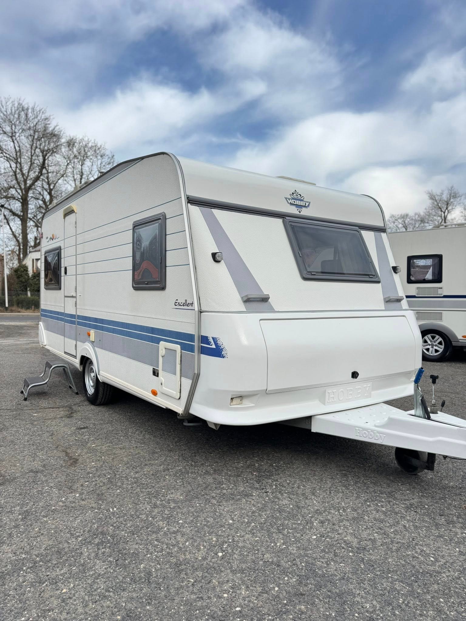 Karavan Hobby Excellent, ideální pro kempování a road tripy, s elegantním designem a pohodlným prostorem.