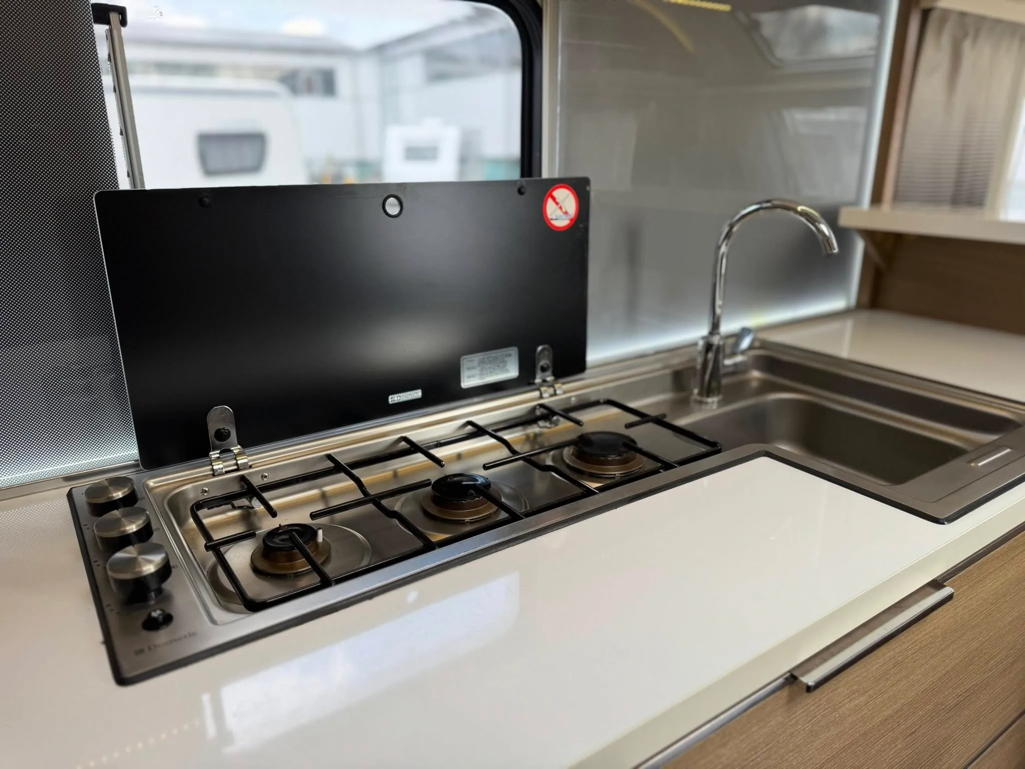 Interiér karavanu s kuchyňským koutem, varná deska a dřez pro skvělou přípravu jídel na cestách.