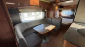 Interiér karavanu s komfortním posezením a kuchyňským koutem. Vhodné pro víkendové výlety.