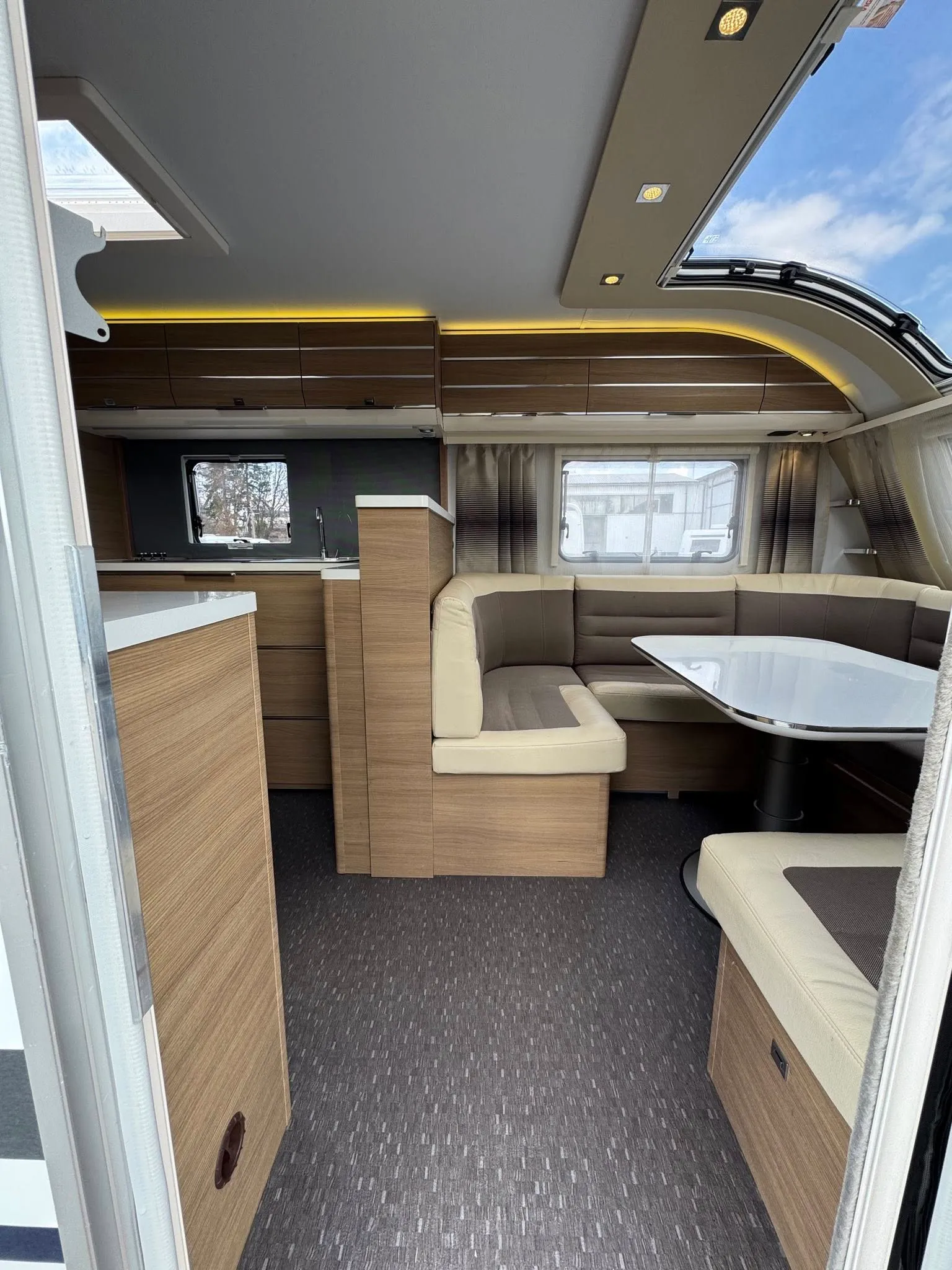 Interiér karavanu s moderním designem a prostornou obytnou částí. Ideální pro pohodlné cestování.