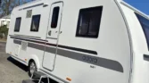 Karavan Adora 563PT s moderním designem, ideální pro rodinné výlety a pohodlné kempování.